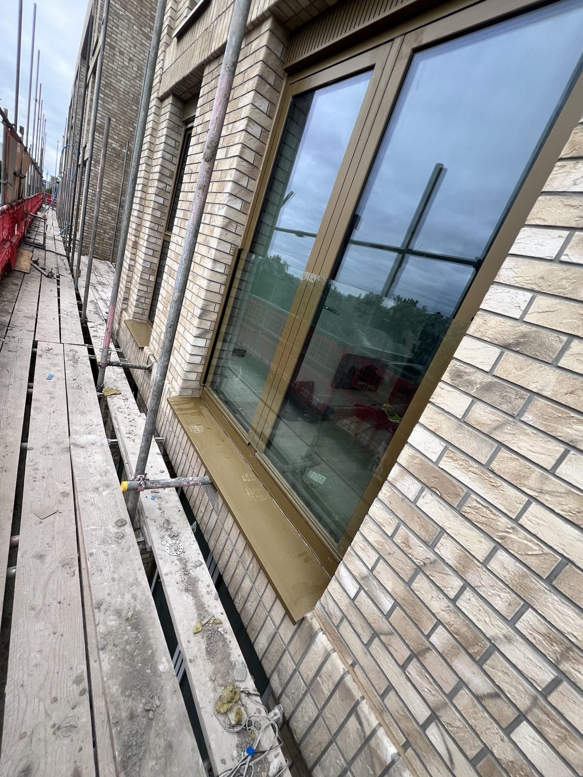 Bronze-framed glazed opening set into pale brickwork, photographed by Kingfisher