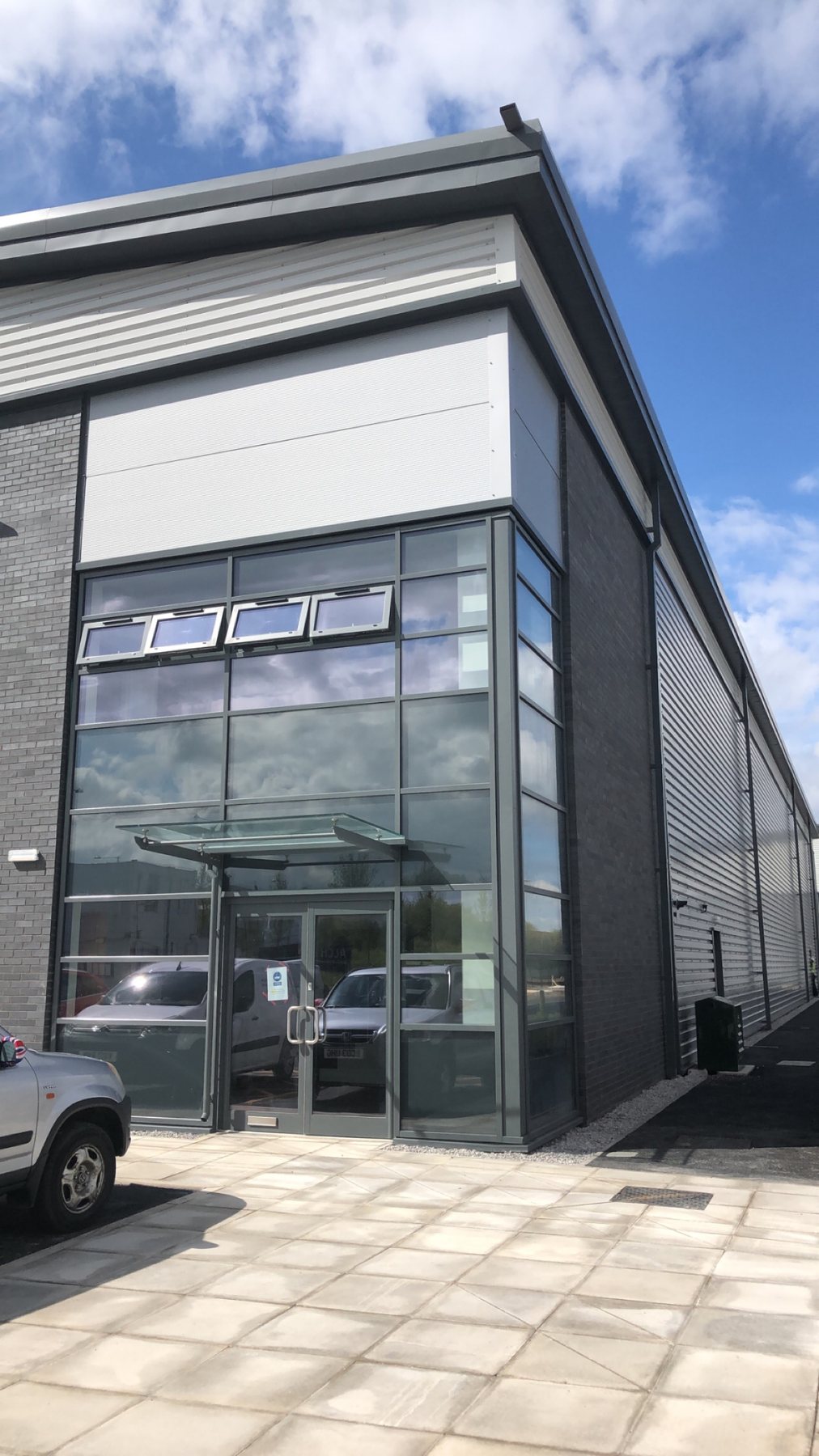 Commercial façade with silver-grey cladding and glazed entrance, photographed by Kingfisher